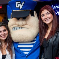 Girls in jackets pose with Louie the Laker